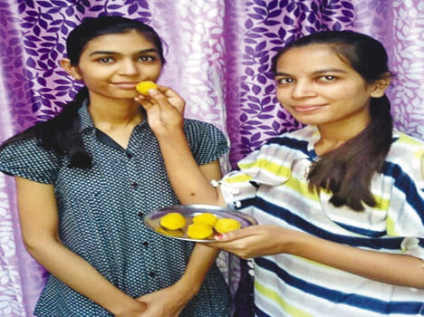   आयुषी को मिठाई खिलाती बड़ी बहन स्मृति
