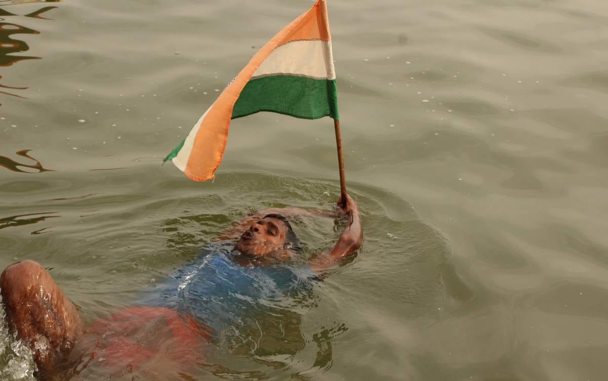 Yoga practice in waves of ganga by a man in varanasi