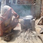 चूल्हे पर खाना बनाती महिला