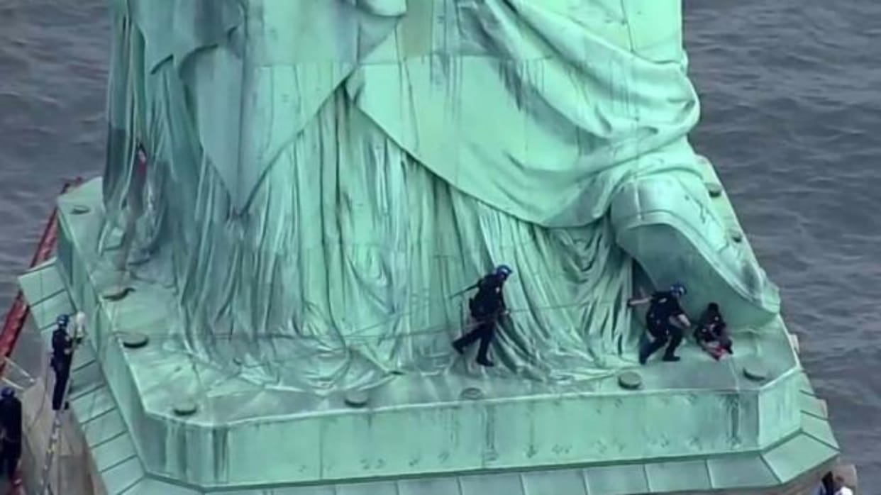 woman taken into custody after she climbed atop Statue of Liberty 