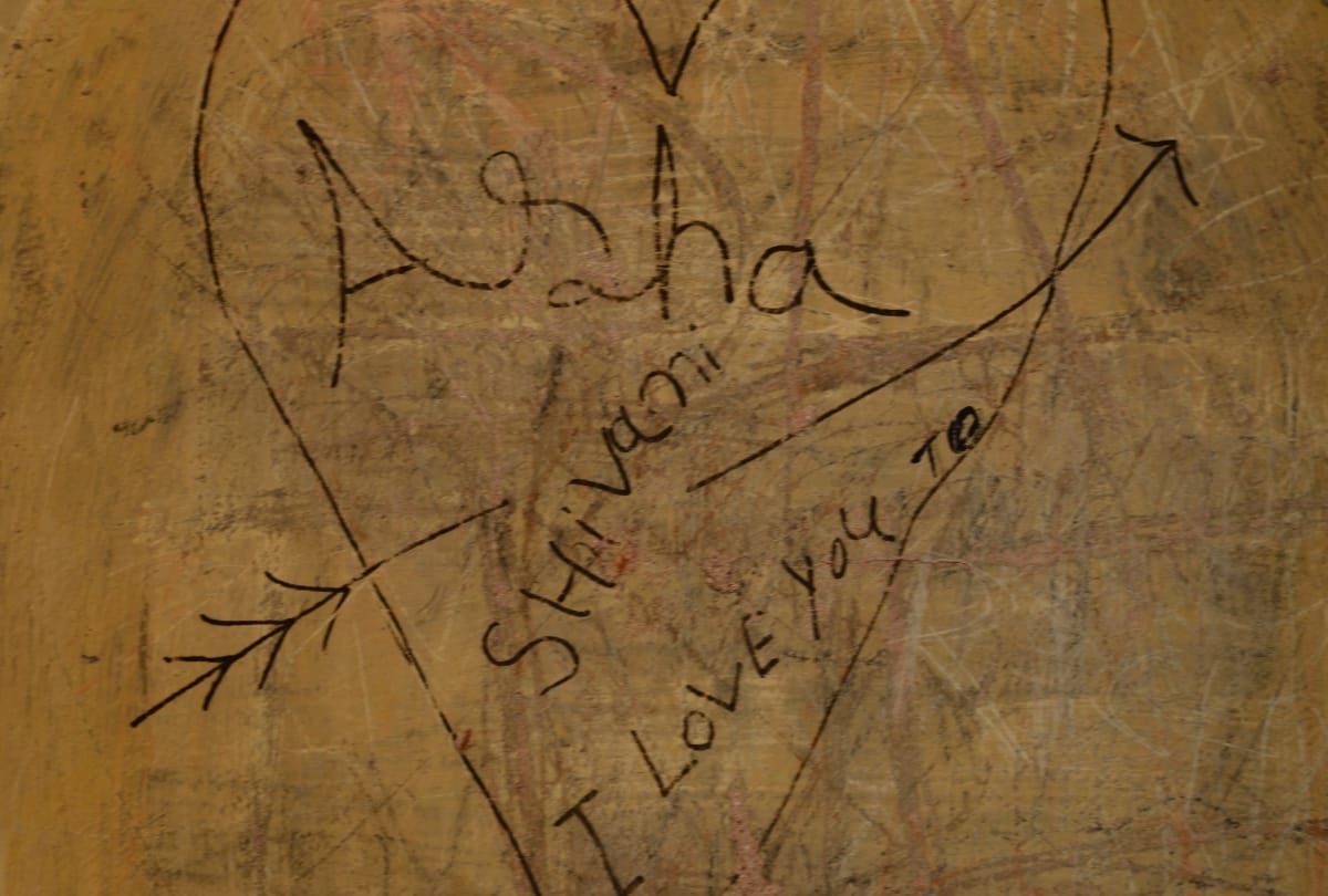 love couples write their names on the wall of imambara