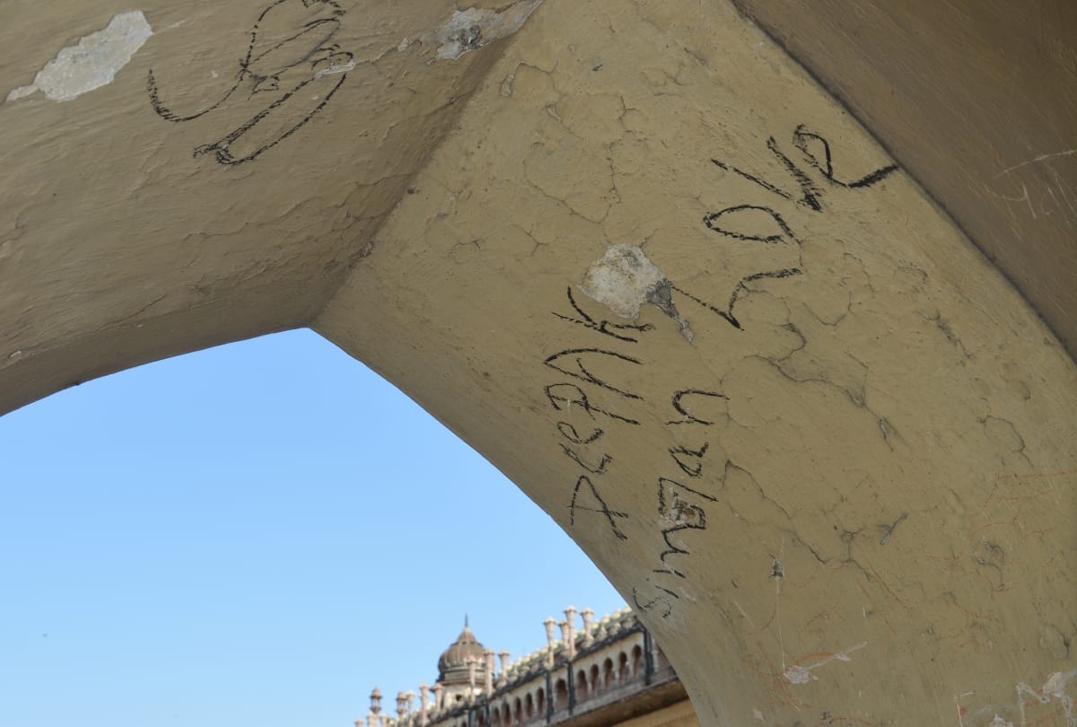 love couples write their names on the wall of imambara