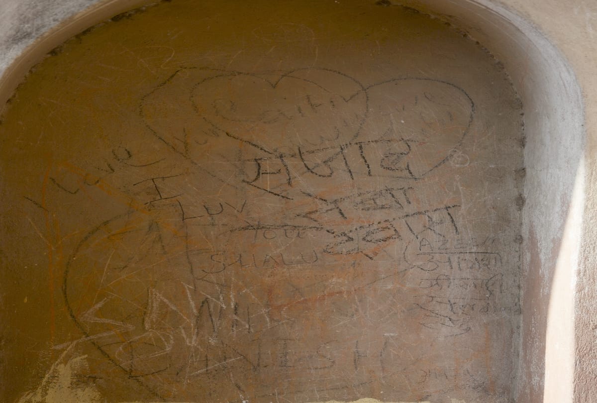 love couples write their names on the wall of imambara