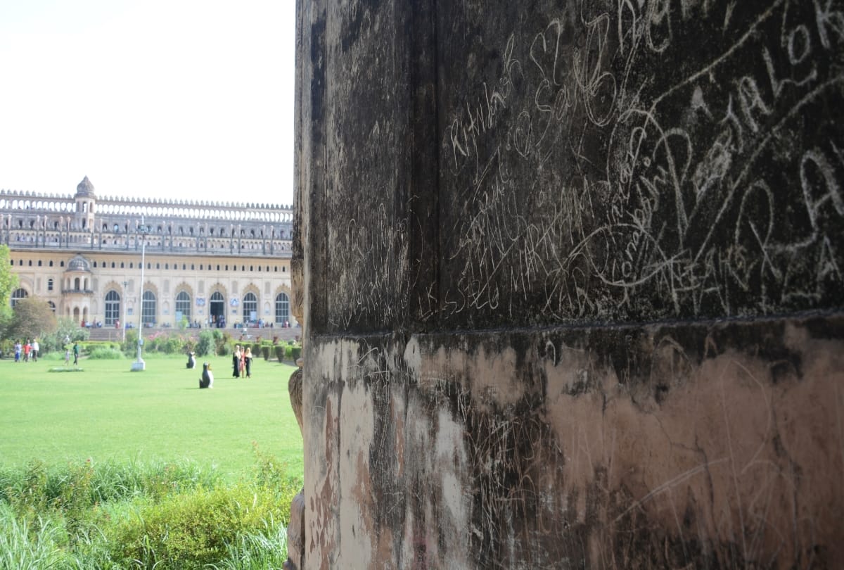 love couples write their names on the wall of imambara