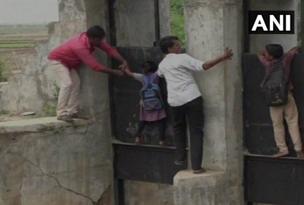 School children crossing a dangers bridge Kheda district in gujrat