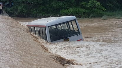 roadway bus submerged near a drain over flowing due to heavy rainfall