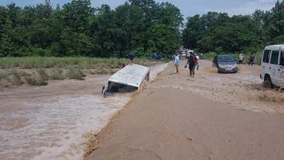 roadway bus submerged near a drain over flowing due to heavy rainfall