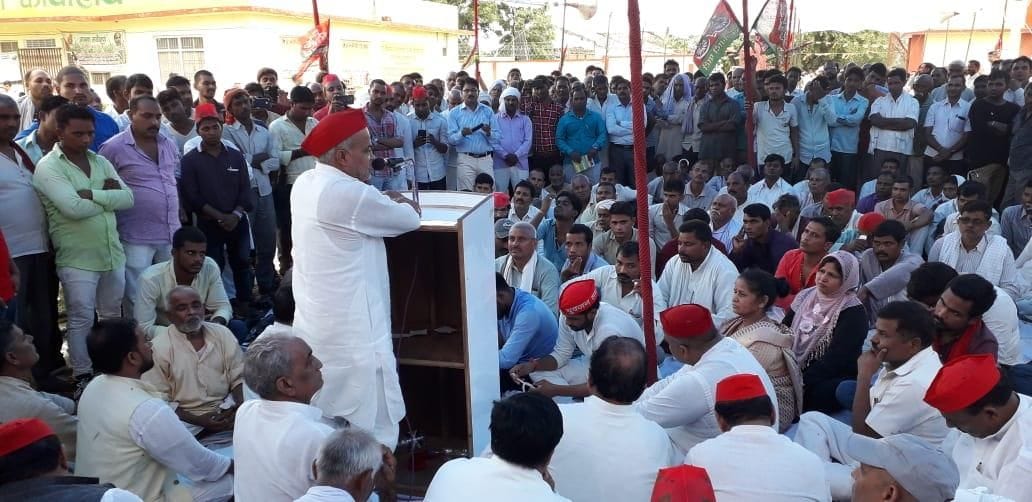 बारिश के बीच सपाइयों ने चीनी मिल गेट पर दिया धरना