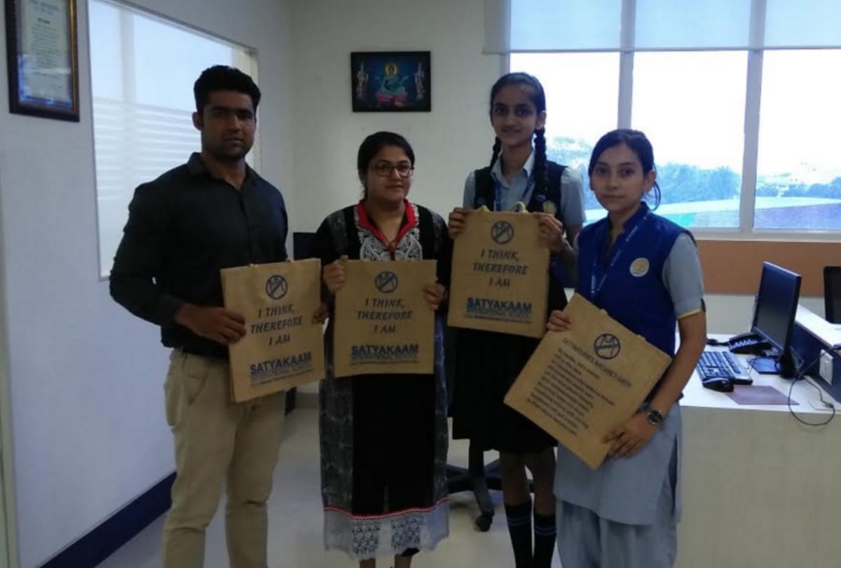 Students organizing campaign to aware people against plastic by distributed jute bags