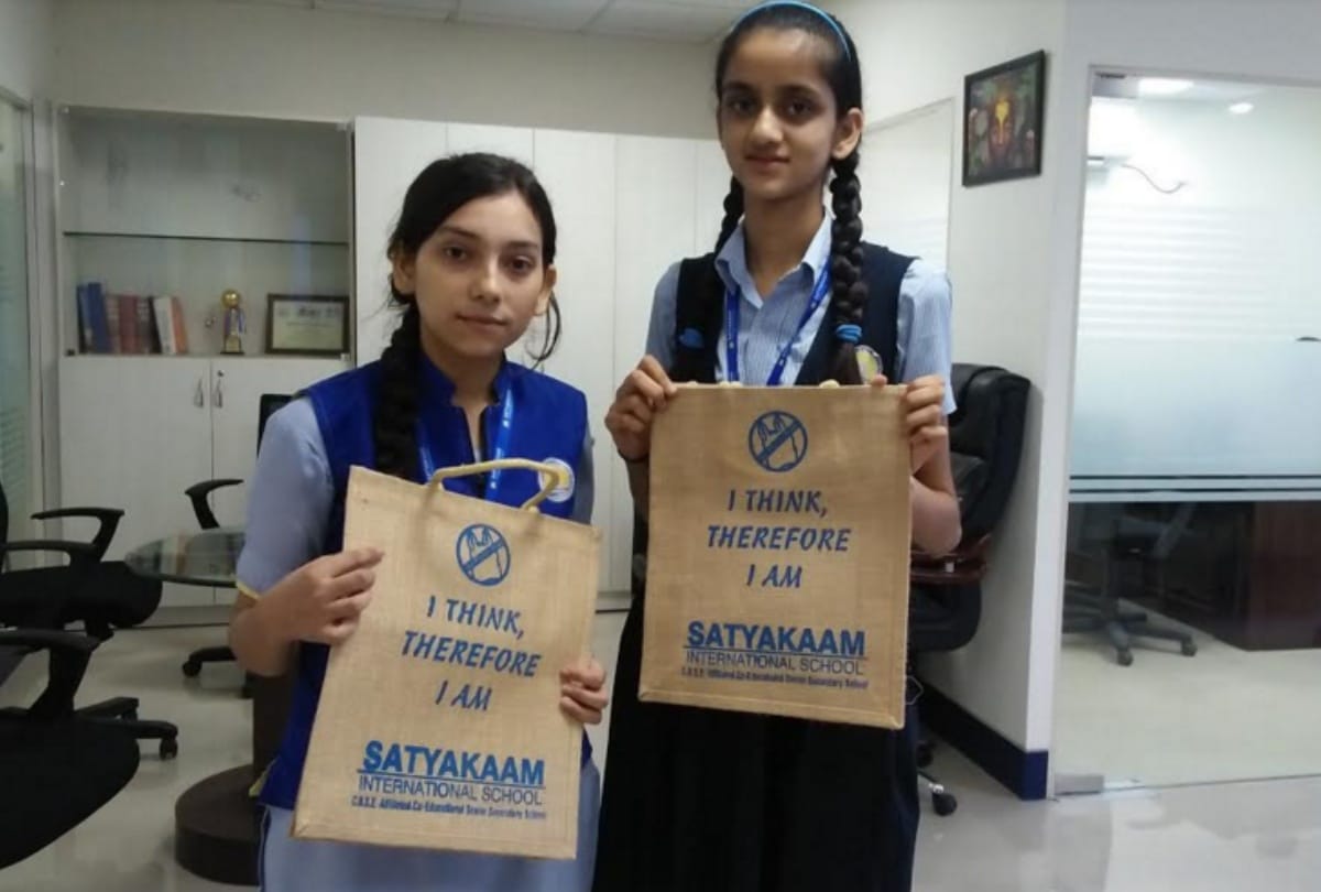 Students organizing campaign to aware people against plastic by distributed jute bags