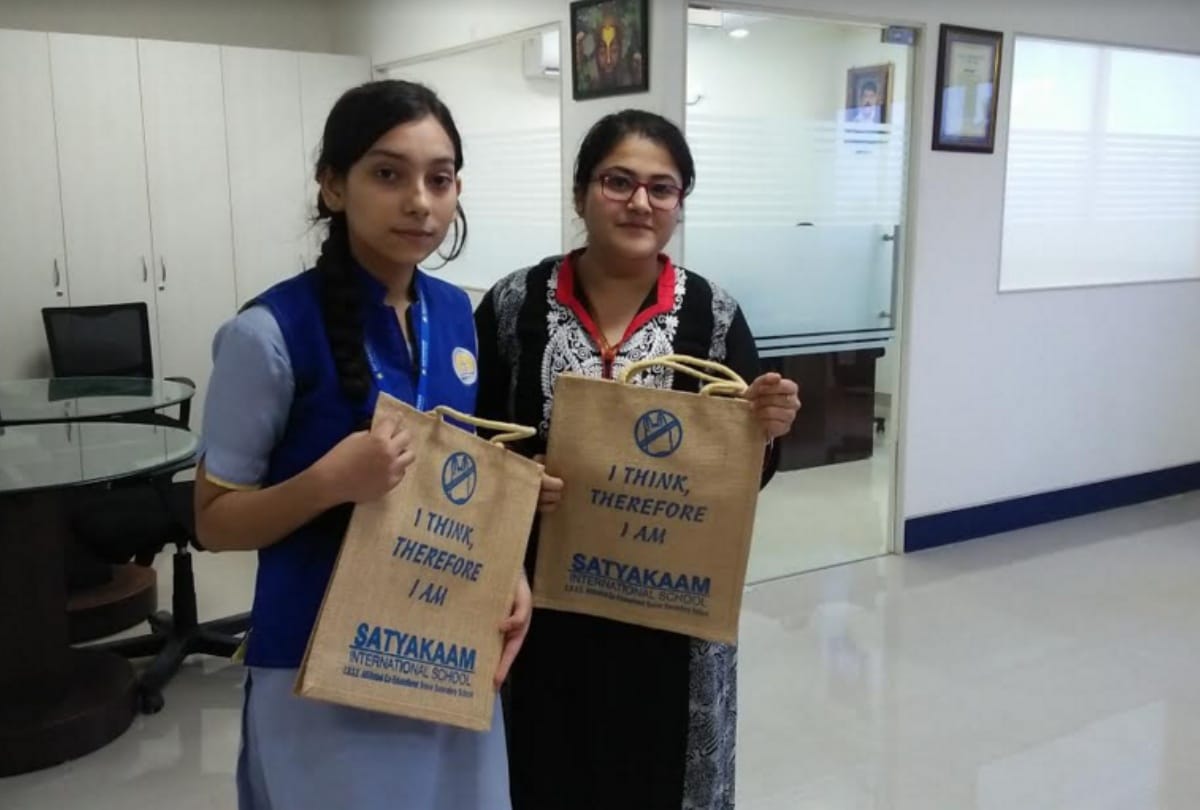 Students organizing campaign to aware people against plastic by distributed jute bags