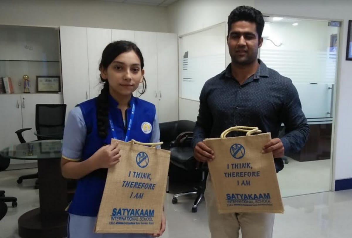 Students organizing campaign to aware people against plastic by distributed jute bags
