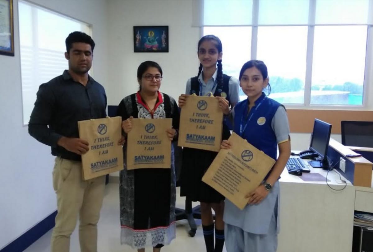 Students organizing campaign to aware people against plastic by distributed jute bags
