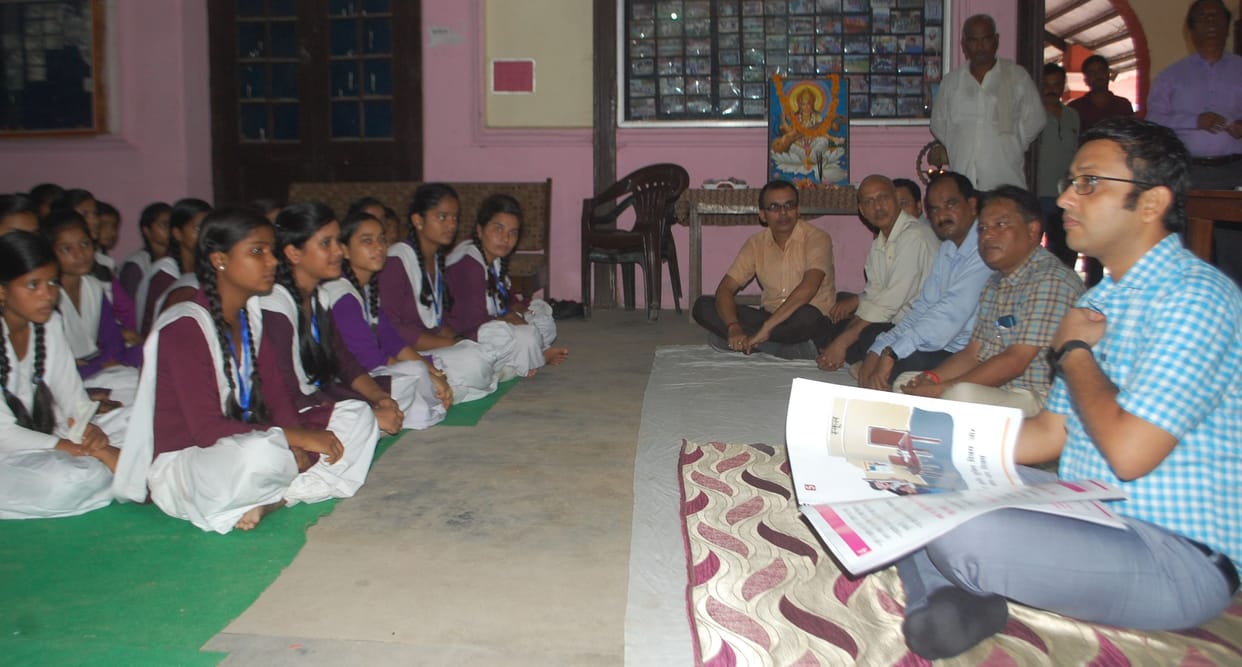 हटवाई टेबल-कुर्सी, बच्चों के साथ दरी पर बैठे डीएम