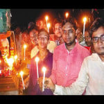 स्वतंत्रता स्मारक अशोक लाट में कैंडल जलाकर श्रद्धांजलि देते युवक।