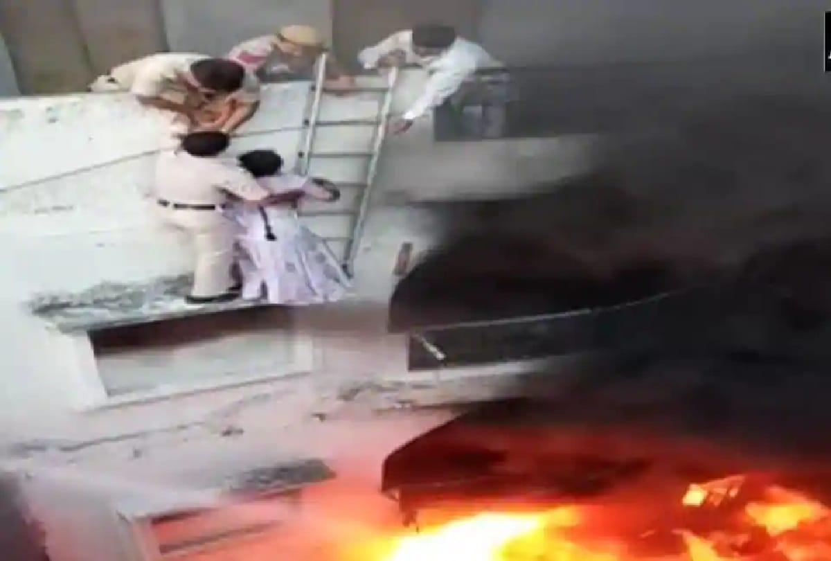 Police personnel rescue the stranded couple in the fire