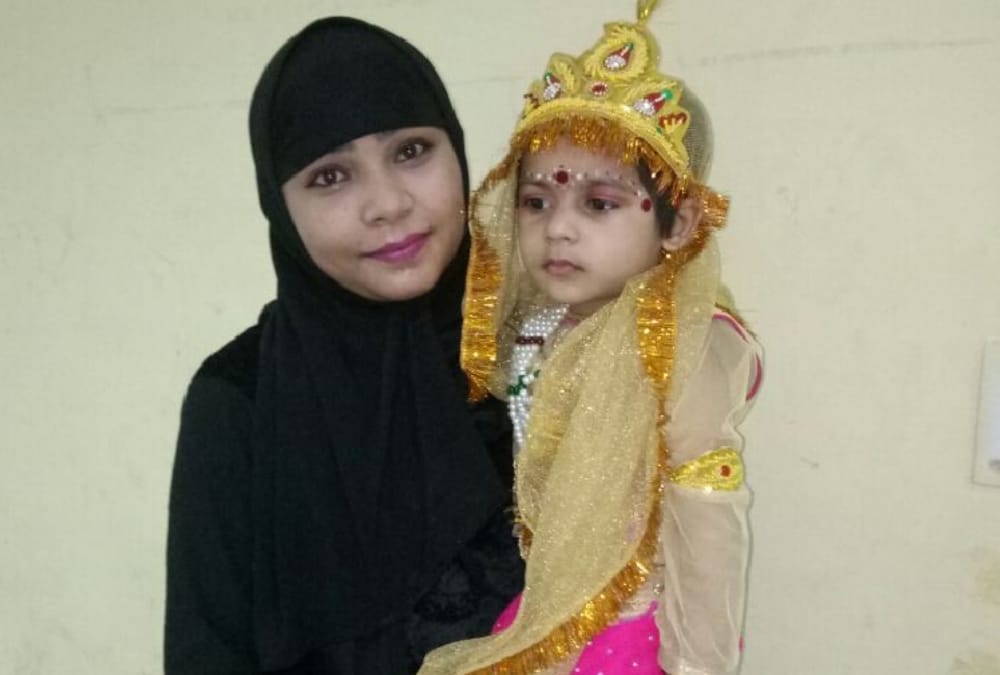 muslim woman decorated her daughter in radha attire.