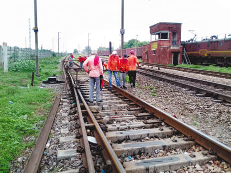 पटरी की मरम्मत करते रेलवे कर्मी।