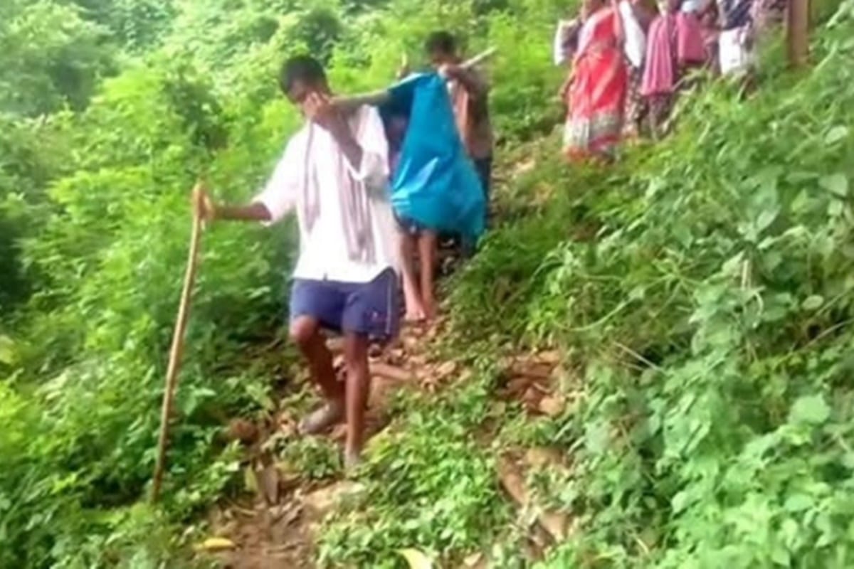 due to lack of road connectivity pregnant woman being carried by her relatives through forest