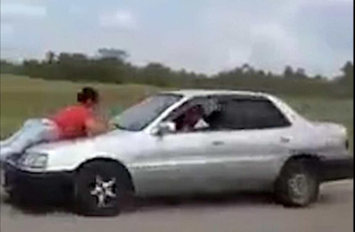A woman was hanging on bonnet of moving car in varanasi