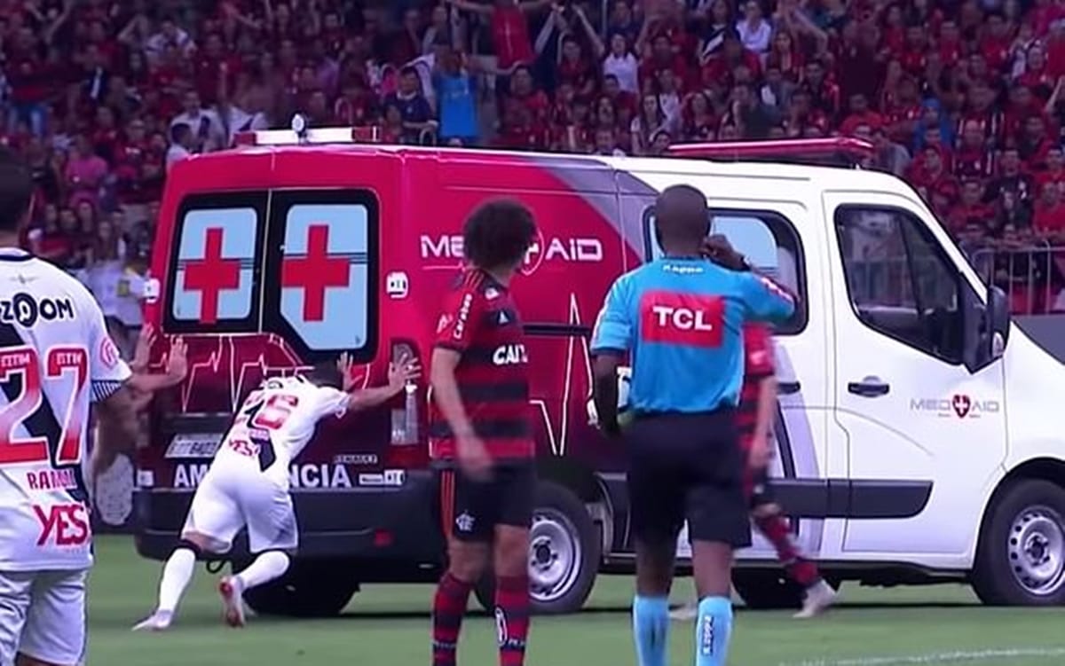 football rival team players get together to push ambulance for injured player