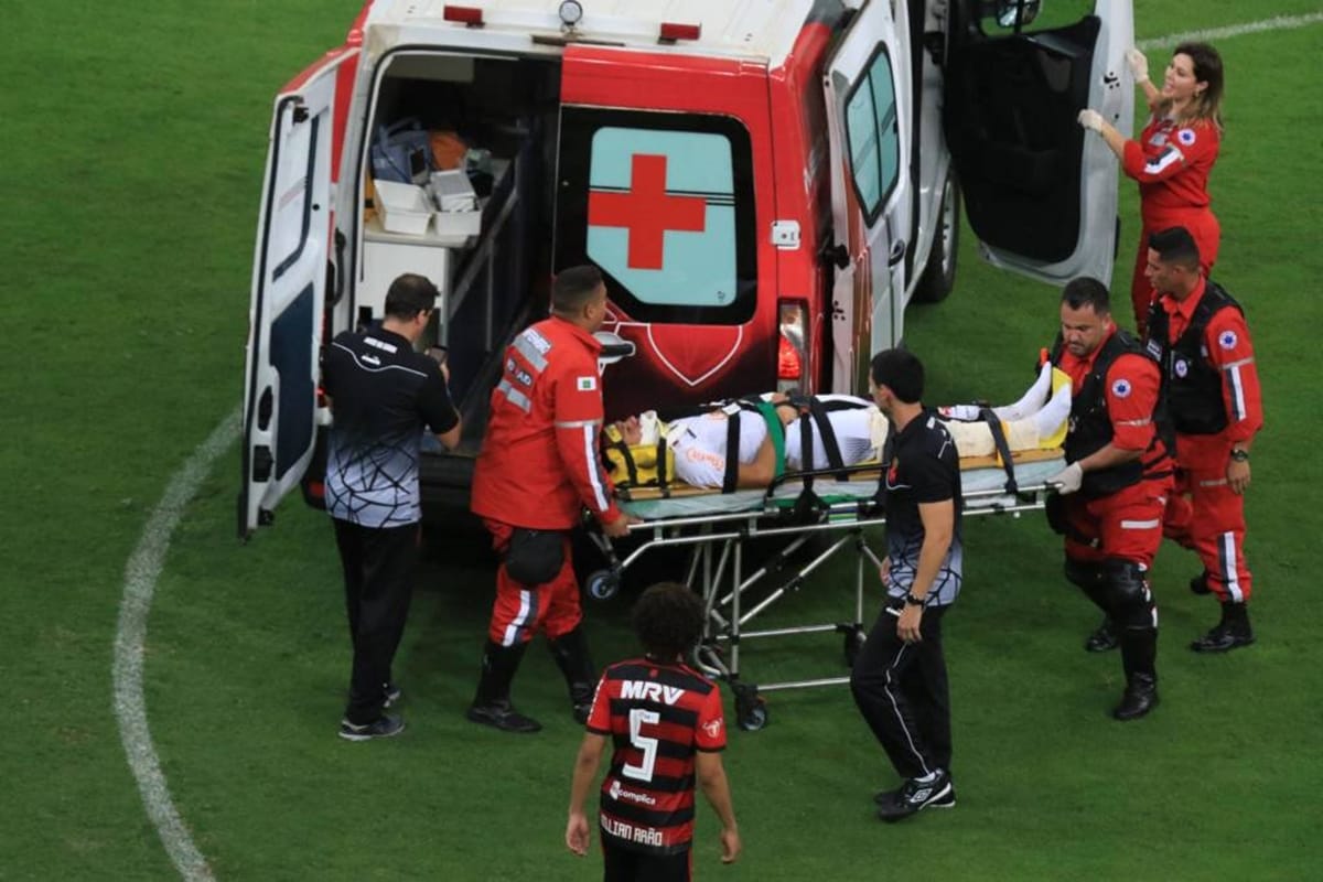 football rival team players get together to push ambulance for injured player