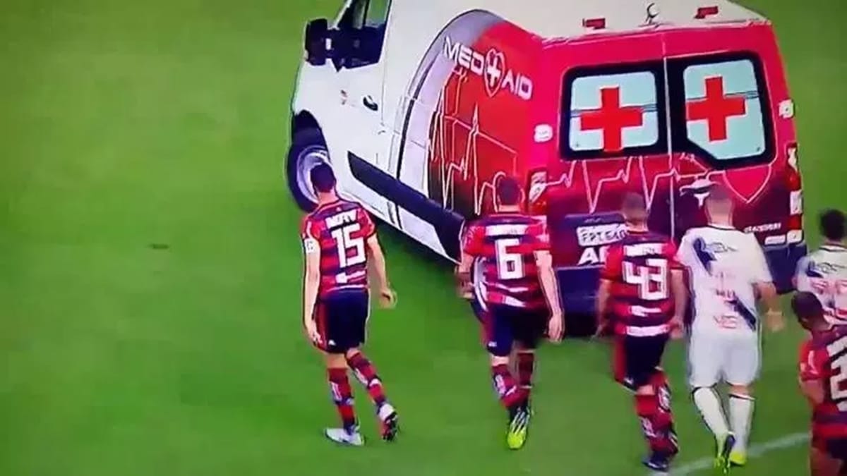 football rival team players get together to push ambulance for injured player