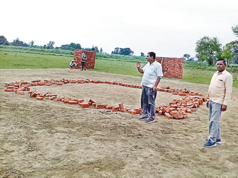 कार्यक्रम स्थल पर हेलीपैड का निर्माण करते कर्मी।