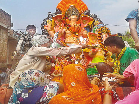 विसर्जन से पूर्व गणेश प्रतिमा की पूजा-अर्चना करते भक्त।