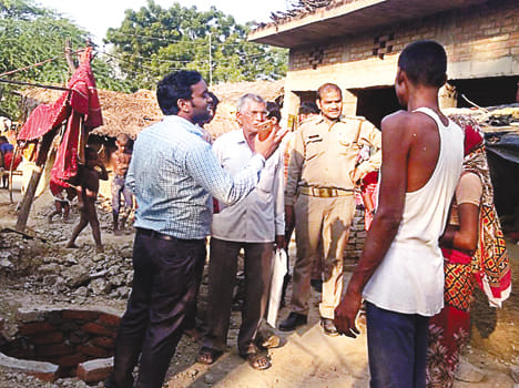 शौचालय निर्माण में लापरवाही करने पर चेतावनी देते जिला प्रेरक व पुलिस।