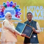 प्रधानमंत्री मोदी को पुस्तक भेंट करते मुख्यमंत्री रावत