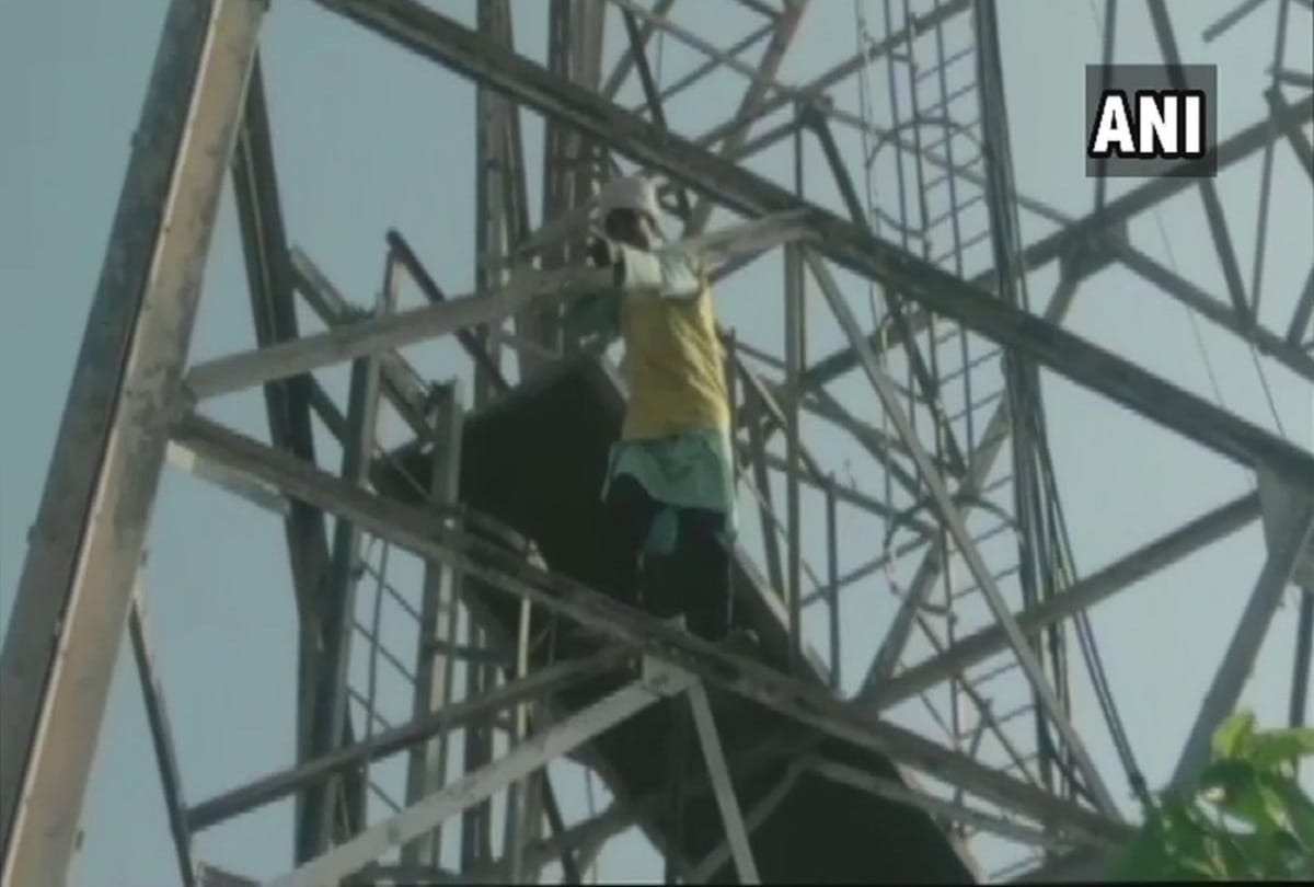 a man climbs on mobile tower over land dispute