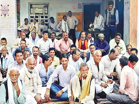 Farmer sitting on lock at sub station