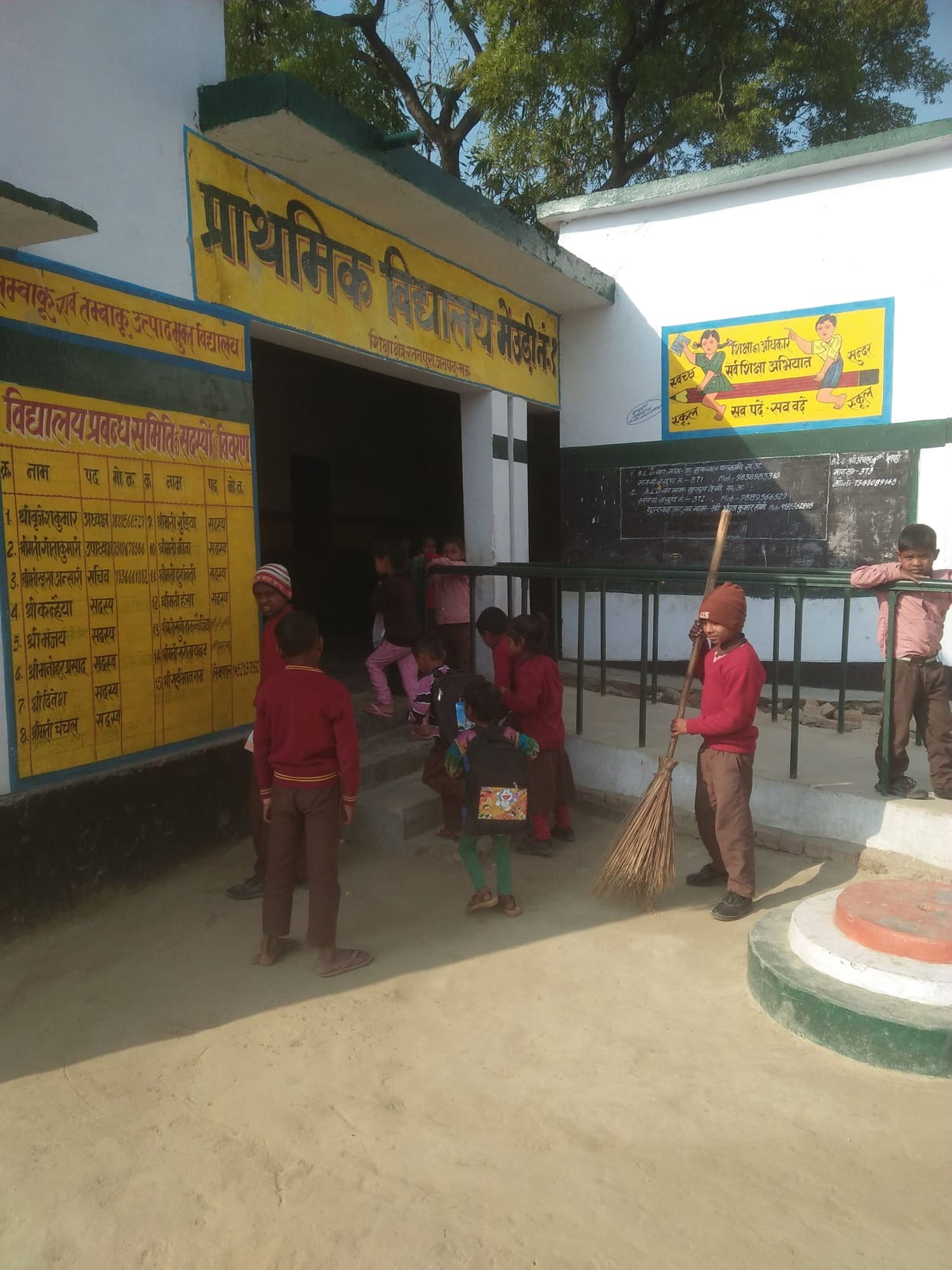 Children carrying broom in school