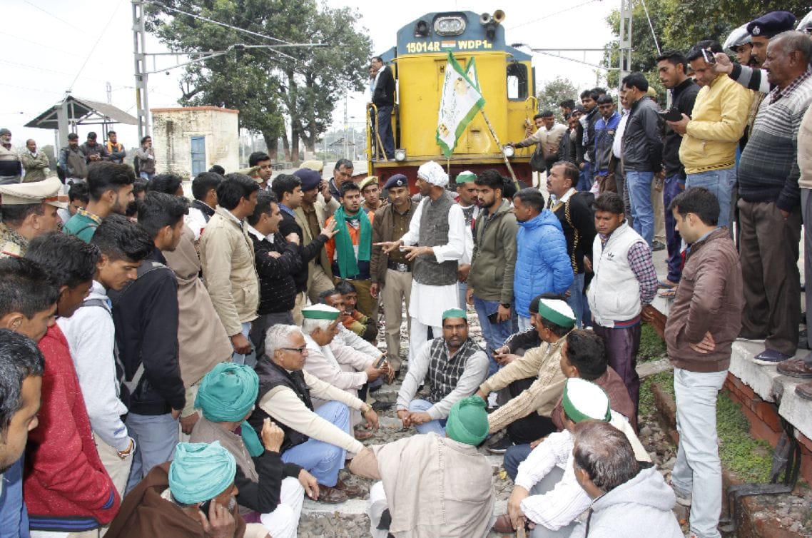 farmer sitting on the track not being paid