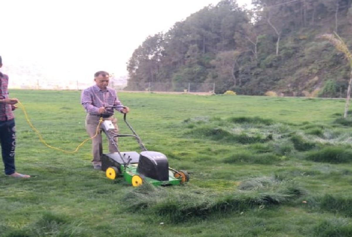 Anil Sharma is cutting grass in the lawn of his new house in Mandi
