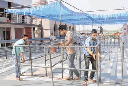 बेल्हा देवी धाम में नवरात्र की तैयारी में परिसर में बैरीकेडिंग करते कार्यकर्ता।