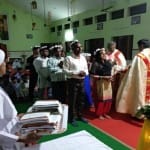 ईस्टर पर्व के अवसर पर लोगों को सम्मानित करते फादर