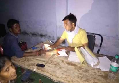 Voting personnel completing paperwork in light of mobile torch