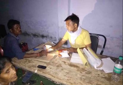 Voting personnel completing paperwork in light of mobile torch