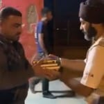शरणार्थी शिविर में कुरान भेंट करता खालसा एड का सदस्य