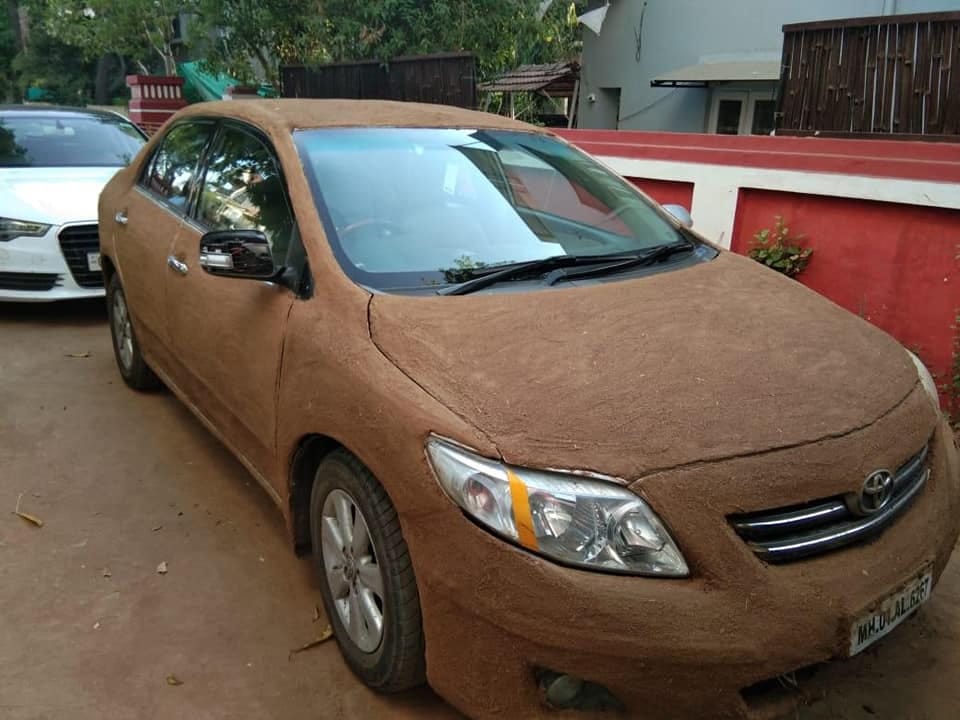 Toyota Corolla Altis plastered with dung and Jaguar XE roof covered with thatched