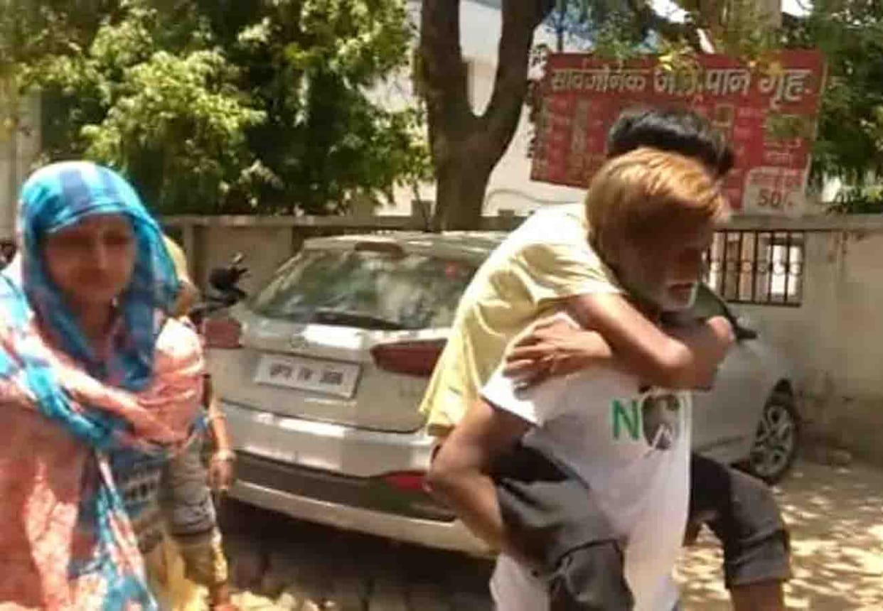 old father take his sick son on his back run in Hallet hospital in kanpur