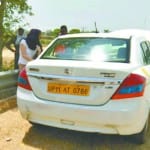 कार के पास खड़ी विदेशी महिला