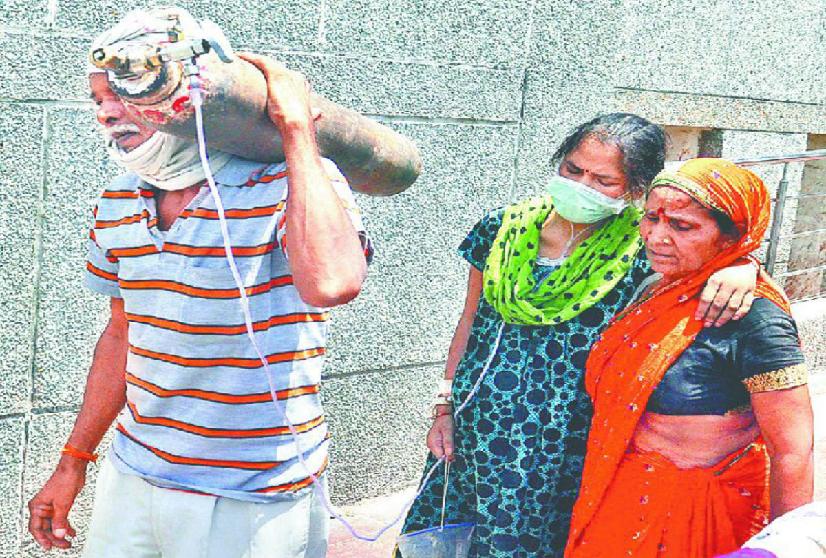 family member of patient carrying oxygen cylinder on shoulders in sn medical college agra