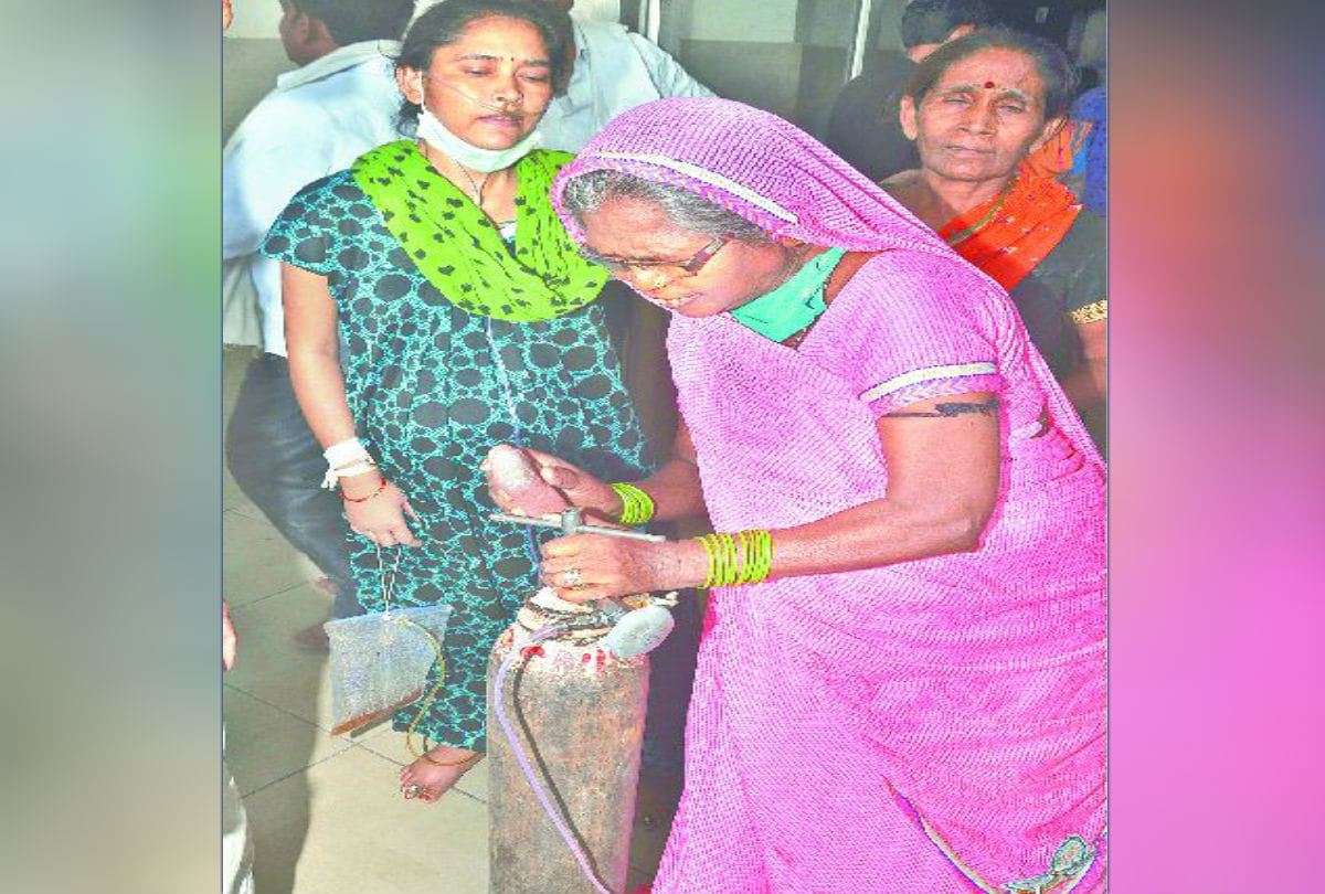 family member of patient carrying oxygen cylinder on shoulders in sn medical college agra