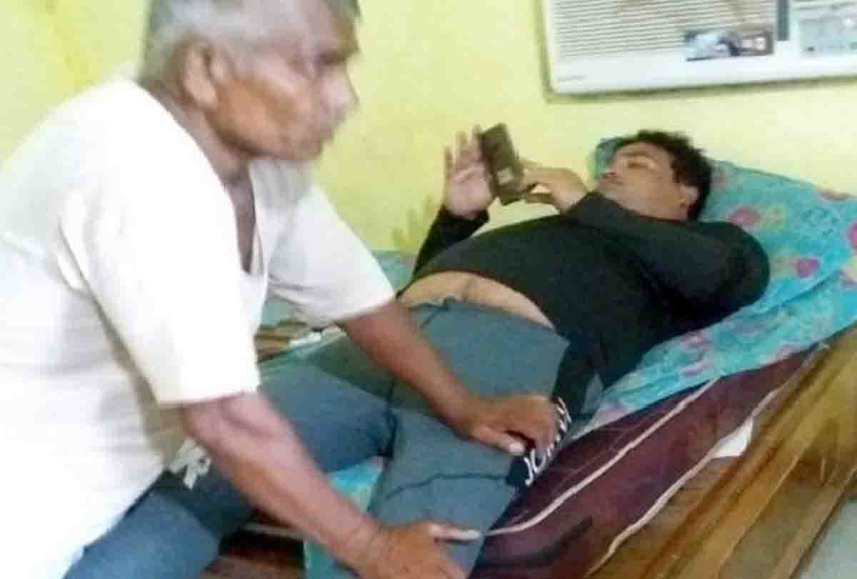 old man giving foot massage to daroga in police station