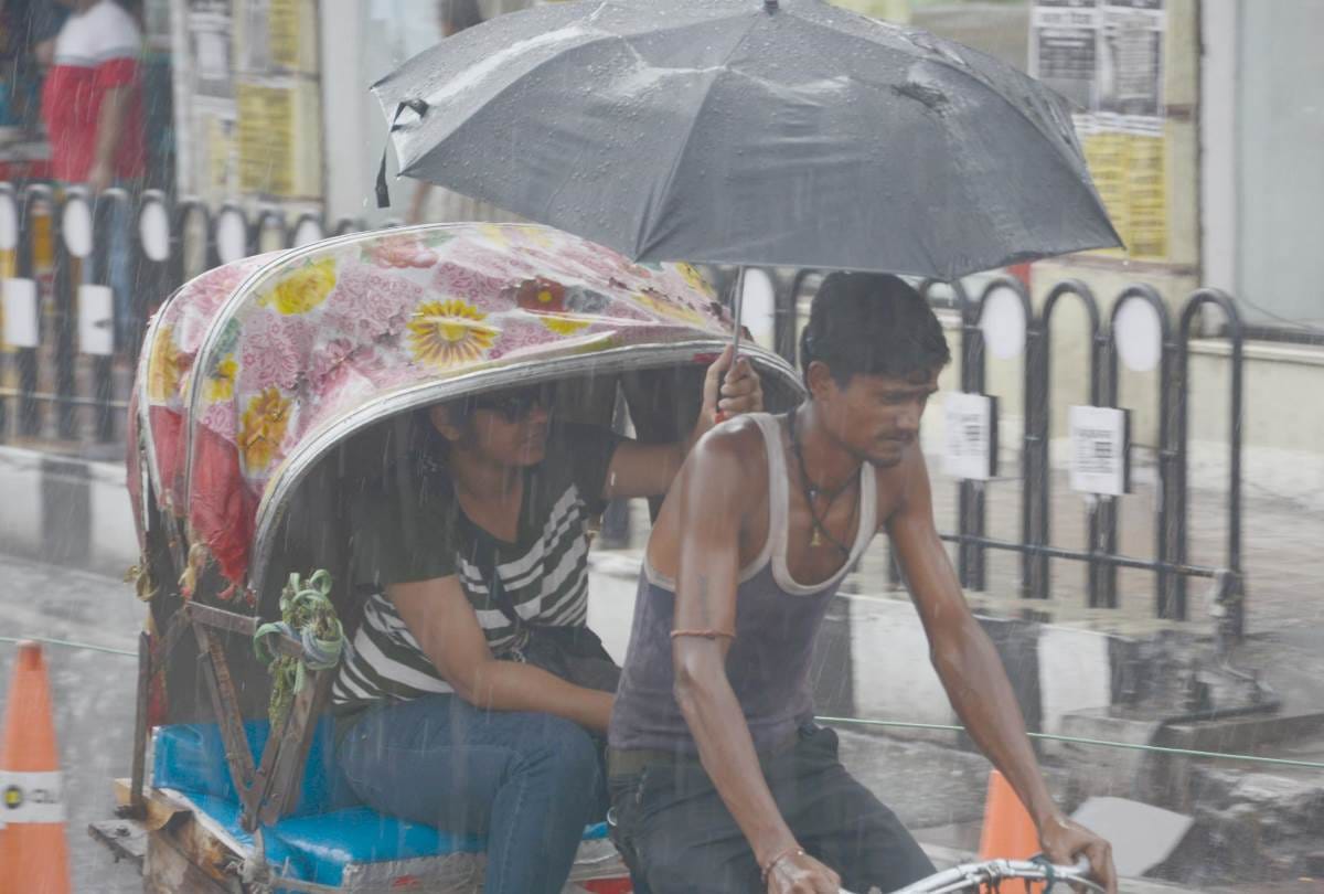 a girl opens her umbrella to save a rickshaw puller from rain