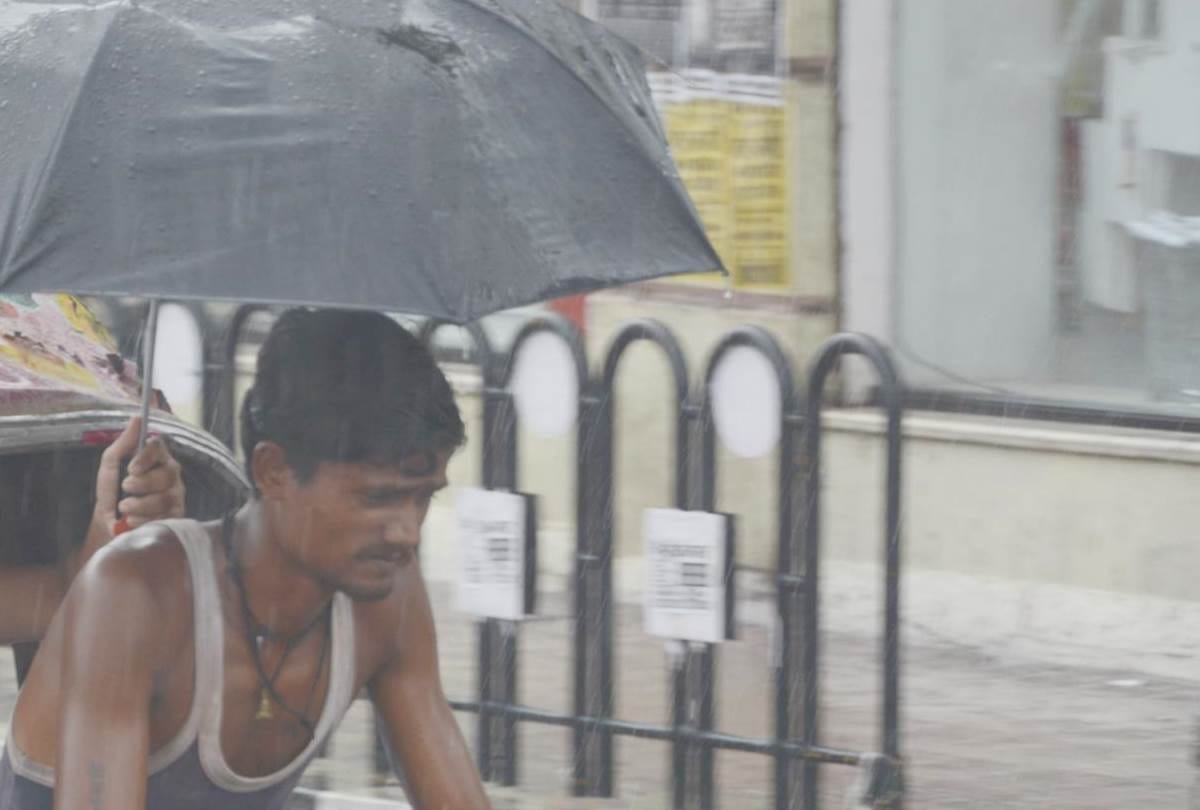a girl opens her umbrella to save a rickshaw puller from rain