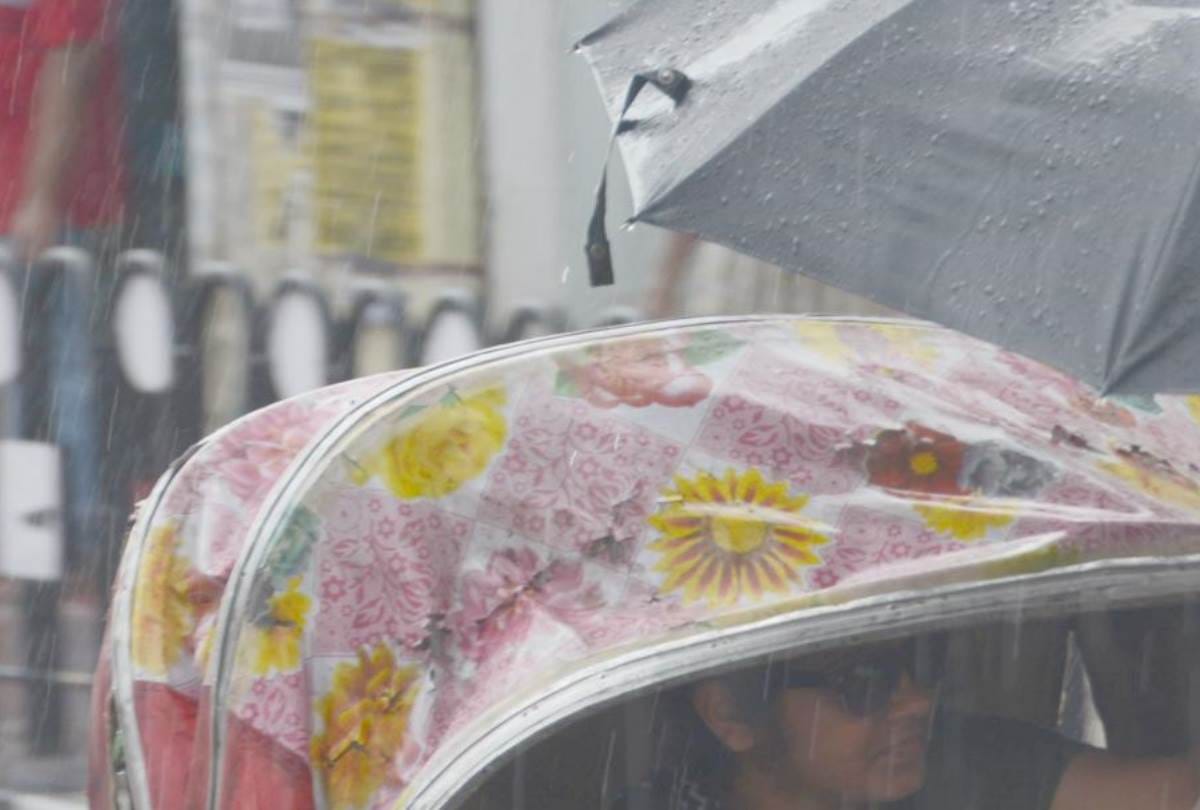 a girl opens her umbrella to save a rickshaw puller from rain